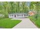 Charming gray home with green lawn, lush trees, and a newly paved driveway at 4734 Campbellton Sw Rd, Atlanta, GA 30331