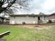 A fenced backyard with a few scattered trees, and a view of the rear of the brick house at 2030 Mark Trl, Decatur, GA 30032