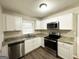 Modern kitchen boasts stainless steel appliances, granite countertops, and ample white cabinetry at 2030 Mark Trl, Decatur, GA 30032