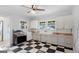 Charming kitchen features black and white checkered floors, vintage cabinets, and updated stainless stove at 110 Bevis Cir, Bowdon, GA 30108