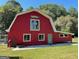 Red barn with white trim, horse accents and green door, situated on a grassy lawn at 225 Banks Rd, Fayetteville, GA 30214