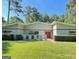 Single story home with a vibrant red front door, manicured lawn and mature landscaping at 225 Banks Rd, Fayetteville, GA 30214