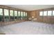 Living room with wood paneling, carpet, and large windows overlooking greenery at 225 Banks Rd, Fayetteville, GA 30214
