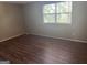 Bedroom featuring new floors, neutral colored walls, and a large window at 923 Regal Path Ln, Decatur, GA 30030