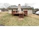Spacious backyard view of a raised deck, with a home exterior showcasing beige siding and chimney at 246 Bridgewood Se Dr, Conyers, GA 30094