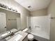 Bright bathroom with a granite countertop, modern fixtures, and a shower-tub combination at 246 Bridgewood Se Dr, Conyers, GA 30094