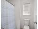 Bathroom features a shower with curtain, toilet, and window at 3426 Bridle Brook Drive Ne Dr, Auburn, GA 30011