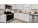 Close up on kitchen featuring white cabinets, stainless steel appliances, and modern countertops at 3426 Bridle Brook Drive Ne Dr, Auburn, GA 30011