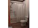 Bathroom showcasing a shower and toilet with a white curtain and shelving at 9000 Edinburg Dr, Winston, GA 30187