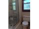 Bathroom showcasing a glass-enclosed shower with a built-in seat and window at 9000 Edinburg Dr, Winston, GA 30187