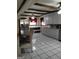 Open kitchen layout featuring white tile floors, breakfast bar, and stainless steel appliances at 9000 Edinburg Dr, Winston, GA 30187