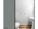 Contemporary half-bathroom with modern fixtures including a pedestal sink, toilet, and warm luxury vinyl plank flooring at 44 Star Spangled Ln, Peachtree City, GA 30269