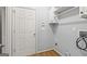 Functional laundry room with white cabinets, shelving, and utility connections at 44 Star Spangled Ln, Peachtree City, GA 30269