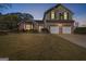 Charming two-story home with brick accents, two-car garage, and well-manicured lawn at dusk at 1022 Gloria Grand Blvd, Mcdonough, GA 30252