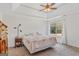 Spacious main bedroom with carpet floors, a ceiling fan, and a large window with wooded backyard view at 1022 Gloria Grand Blvd, Mcdonough, GA 30252