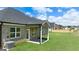 Spacious backyard with lush green grass, a covered patio and a home with brick and stone accents at 1724 Goodwin Dr # 74, Hampton, GA 30228