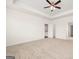Bright Primary bedroom featuring neutral carpeting, tray ceiling, and an open doorway into the bathroom at 1724 Goodwin Dr # 74, Hampton, GA 30228