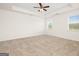 Spacious bedroom featuring tray ceilings, plush carpeting, and two bright windows offering views of the outdoors at 1724 Goodwin Dr # 74, Hampton, GA 30228