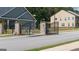 Gated entrance to a community with well-maintained landscaping and a paved street with neighborhood homes in the background at 1724 Goodwin Dr # 74, Hampton, GA 30228