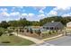 Community pool featuring blue lounge chairs and umbrellas, surrounded by green lawns and lush trees at 1724 Goodwin Dr # 74, Hampton, GA 30228