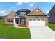 Charming brick home with a manicured lawn, complemented by a pristine driveway and attached garage at 1724 Goodwin Dr # 74, Hampton, GA 30228