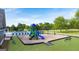 Community playground with slides, climbing structures, and a swing set, surrounded by green space and trees at 1724 Goodwin Dr # 74, Hampton, GA 30228
