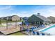 Community pool, clubhouse, splash pad, and playground with lounge seating and umbrellas at 1724 Goodwin Dr # 74, Hampton, GA 30228