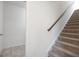 Carpeted staircase with wooden handrail leading to the upper level of the home at 1724 Goodwin Dr # 74, Hampton, GA 30228