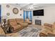 Inviting living room with a cozy fireplace, plush couches, and a ceiling fan for added comfort at 141 Whistle Way, Locust Grove, GA 30248
