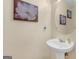 Well-lit powder room featuring a modern pedestal sink and decorative artwork at 141 Whistle Way, Locust Grove, GA 30248