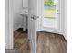 This powder room features wood look flooring, a modern pedestal sink, and a window with a view at 4856 Station Ln # 21, Union City, GA 30349