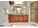 Bathroom vanity with granite countertop, double sinks, walk-in shower with travertine surround, and tile flooring at 550 Wentworth Ct, Fayetteville, GA 30215