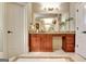 Bathroom vanity features a granite countertop, wall-to-wall mirror, wood cabinets, and travertine tile flooring at 550 Wentworth Ct, Fayetteville, GA 30215
