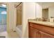 Bathroom with granite vanity, cherry cabinets, and a shower with a tile surround at 550 Wentworth Ct, Fayetteville, GA 30215