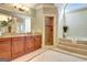 Bathroom featuring a step-up soaking tub, walk-in shower, vanity, large mirror, and tile floor at 550 Wentworth Ct, Fayetteville, GA 30215