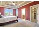 Bedroom showcases tray ceiling, ceiling fan, windows with backyard views, and a walk-in closet at 550 Wentworth Ct, Fayetteville, GA 30215
