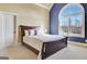 Bedroom featuring a large arched window, neutral walls, and a cozy bed with decorative pillows at 550 Wentworth Ct, Fayetteville, GA 30215