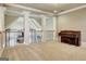 Large bonus room showcases a piano, neutral carpet and wall colors, and a wrought iron railing at 550 Wentworth Ct, Fayetteville, GA 30215