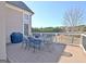 Outdoor deck area features metal table and chairs, overlooking wooded scenery and neighborhood at 550 Wentworth Ct, Fayetteville, GA 30215