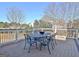 Outdoor deck area features metal table and chairs, overlooking wooded scenery and neighborhood at 550 Wentworth Ct, Fayetteville, GA 30215