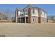 This home's exterior offers multiple balconies, stone accents, and a covered patio area below at 550 Wentworth Ct, Fayetteville, GA 30215