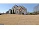 Elegant two-story home featuring a stone and stucco exterior, decorative gables, and a well-manicured lawn at 550 Wentworth Ct, Fayetteville, GA 30215