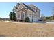 Beautiful home with a three-car garage, stone accents, and manicured landscaping on a sunny day at 550 Wentworth Ct, Fayetteville, GA 30215