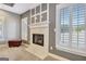 A fireplace with decorative stonework is centered between two shuttered windows at 550 Wentworth Ct, Fayetteville, GA 30215