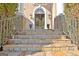 Elegant stone staircase leading to a grand entrance with decorative lamps and a glimpse of the interior at 550 Wentworth Ct, Fayetteville, GA 30215