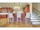 Kitchen island with bar seating, hardwood floors, granite counters, and wooden cabinets in a modern design at 550 Wentworth Ct, Fayetteville, GA 30215