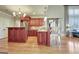 Open kitchen with island, wooden cabinets, stainless appliances, and wood floors at 550 Wentworth Ct, Fayetteville, GA 30215