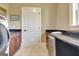 Neat laundry area featuring granite counters, wood cabinets, and modern appliances for laundry at 550 Wentworth Ct, Fayetteville, GA 30215
