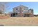 Expansive rear of the home featuring a covered deck and stone accents, complemented by a well-maintained lawn at 550 Wentworth Ct, Fayetteville, GA 30215