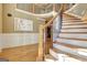 Elegant curved staircase with oak treads, white risers, black iron balusters, and wood railing at 550 Wentworth Ct, Fayetteville, GA 30215